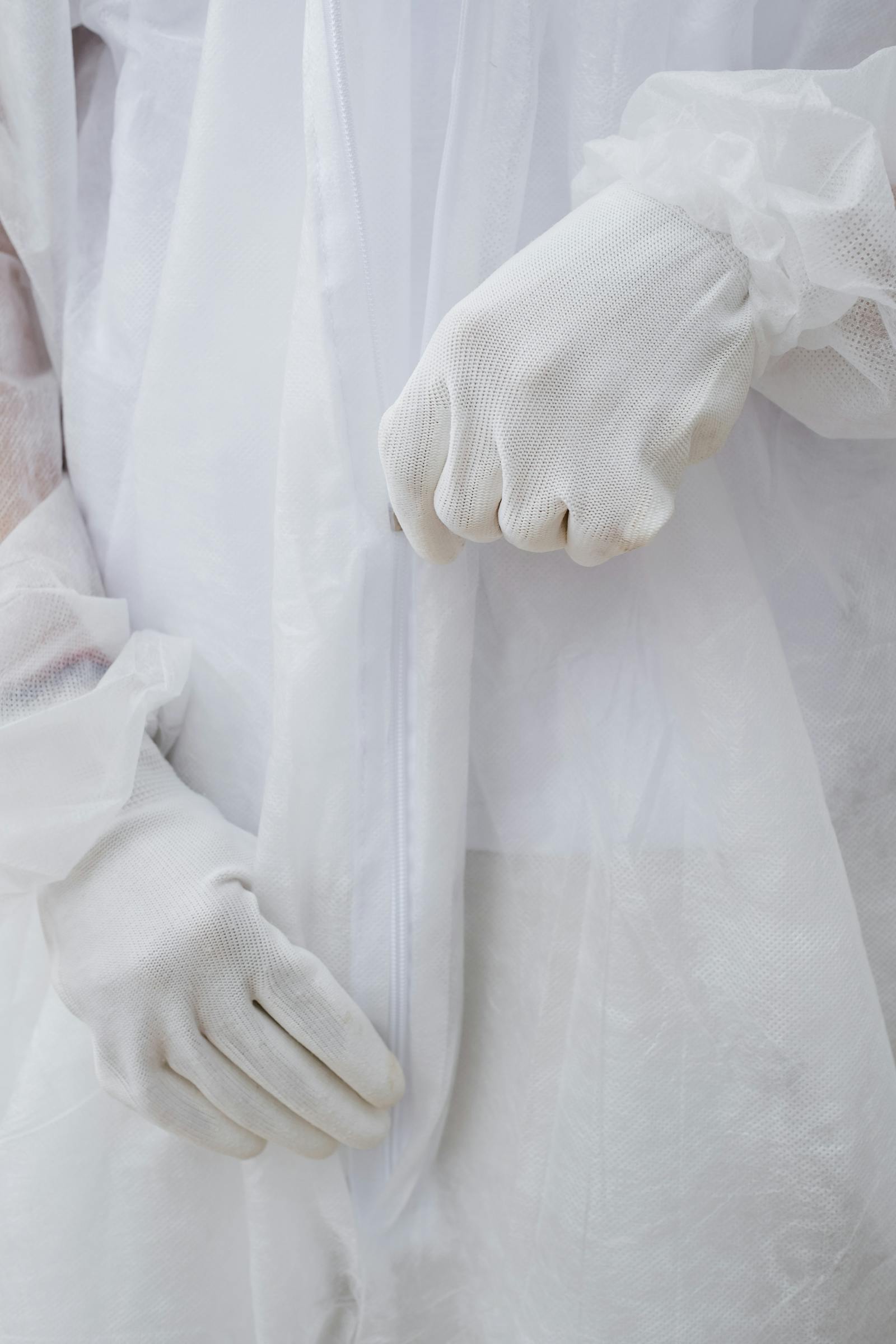 Close-up of protective hazmat suit gloves during preparation