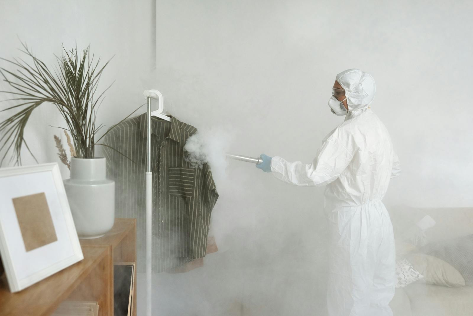 Protective-suit worker fogging a room with disinfectant